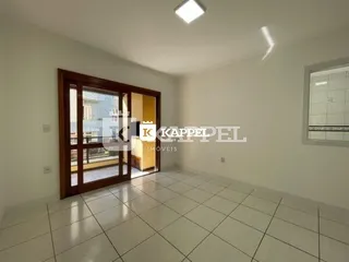 Vista interna de um cômodo com piso de cerâmica e porta de madeira.