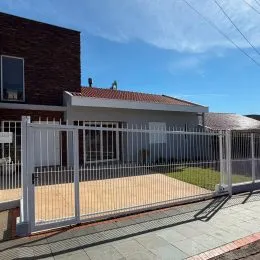 Fachada de uma residência com cerca branca em Lajeado.
