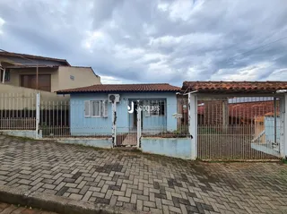 Fachada de uma residência em Lajeado, Brasil, com cerca e pavimento de tijolos.