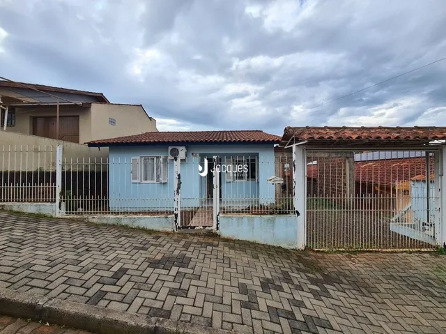 Fachada de uma residência em Lajeado, Brasil, com cerca e pavimento de tijolos.