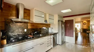 Foto de uma cozinha moderna com armários brancos e bancada escura.