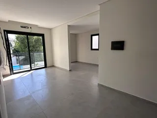 Sala de estar com piso de cerâmica e porta de vidro.