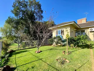 Vista externa de uma residência com jardim gramado e árvores em Lajeado, Brasil.
