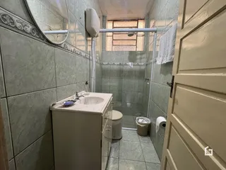 Foto de um banheiro com revestimento de cerâmica e box de vidro.