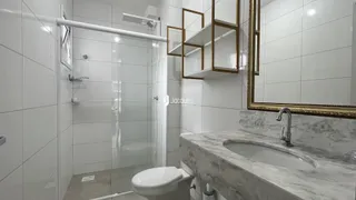 Foto de um banheiro com box de vidro e bancada de mármore.