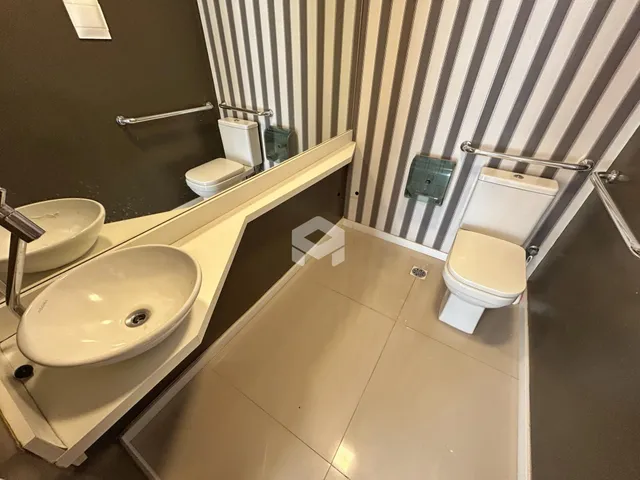 Foto de um banheiro com pias e vasos sanitários em um imóvel.