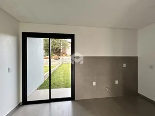 Sala de estar com porta de vidro que dá acesso a um jardim externo.