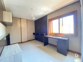 Ambiente interno de uma sala com piso claro e grande janela.