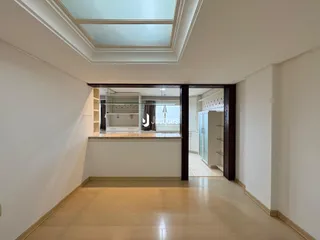 Vista de um corredor interno com passagem para a cozinha.