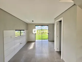 Hall de entrada com piso de cerâmica e vista para um jardim verde.