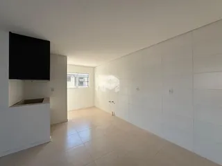 Interior de uma sala de estar com piso de cerâmica clara e paredes brancas.