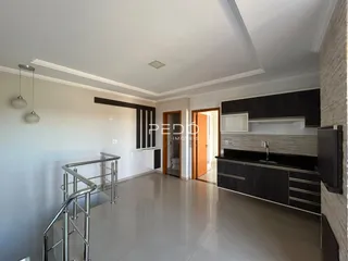 Ambiente interno de uma sala de estar com cozinha moderna em Lajeado.