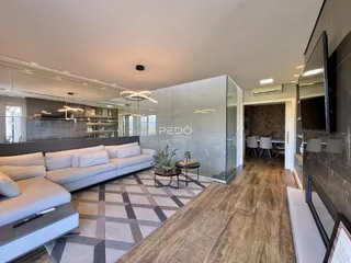 Sala de estar moderna com piso de madeira e sofá cinza.