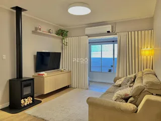 Sala de estar com sofá e televisão em um apartamento no Brasil.