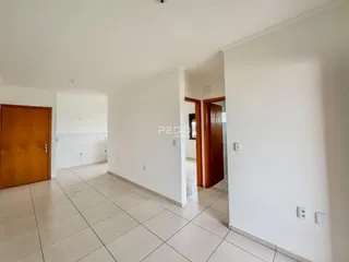 Interior de um corredor com piso de cerâmica clara e portas de madeira.