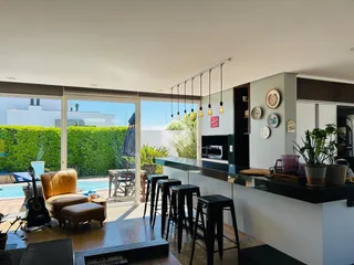 Sala de estar com acesso a uma área externa com piscina e jardim.