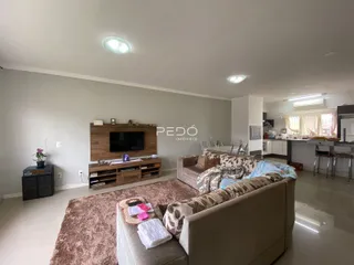 Sala de estar moderna com sofá e televisão em um imóvel no Brasil.