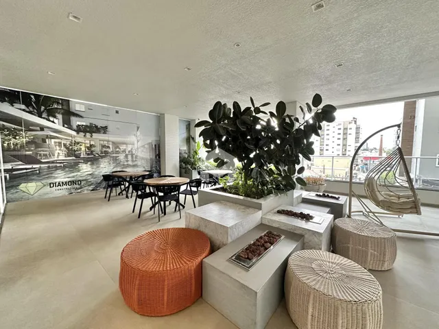 Ambiente interno de uma sala ampla com vista para o exterior e decoração de plantas.