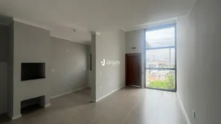 Sala de estar com piso claro e grandes janelas em um imóvel em Lajeado.