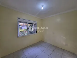 Interior de um cômodo com paredes amarelas e piso de cerâmica.