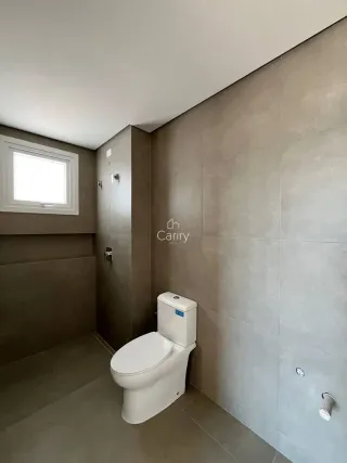 Foto de um banheiro interno com piso de cerâmica e vaso sanitário branco.
