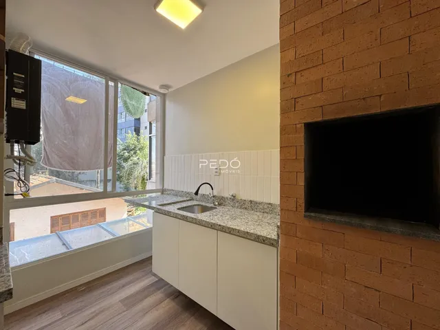 Sala de estar com janela e cozinha em apartamento no Brasil.