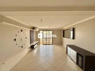 Foto do interior de uma sala ampla com piso de cerâmica e detalhes arquitetônicos.
