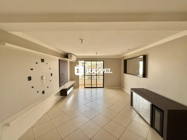 Foto do interior de uma sala ampla com piso de cerâmica e detalhes arquitetônicos.