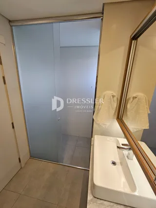 Vista de um banheiro com uma banheira e porta de vidro.