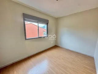Ambiente interno de uma sala com piso de madeira clara.