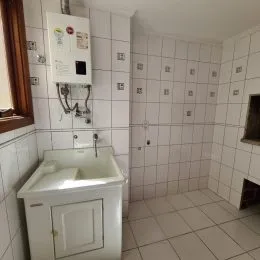 Foto de um banheiro com revestimento de azulejos brancos.