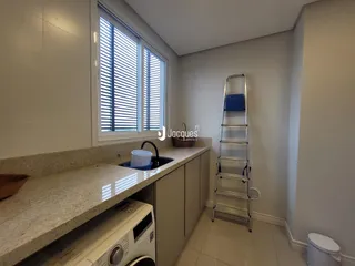 Vista interna de uma cozinha com bancada e janela em um imóvel no Brasil.
