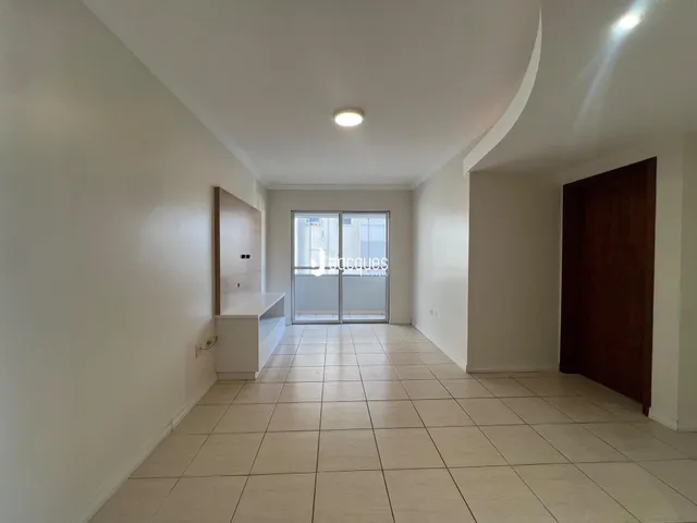 Hall de entrada com piso de cerâmica e paredes brancas.
