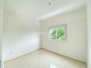 Sala de estar com piso de cerâmica e janela iluminada.