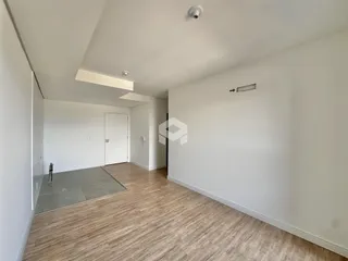 A foto mostra um corredor interno com piso de madeira clara.