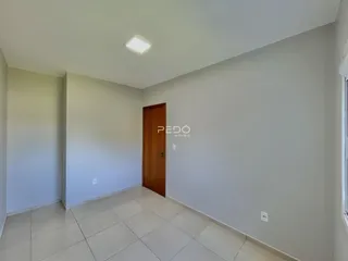 Hall de entrada com piso de cerâmica e porta de madeira.