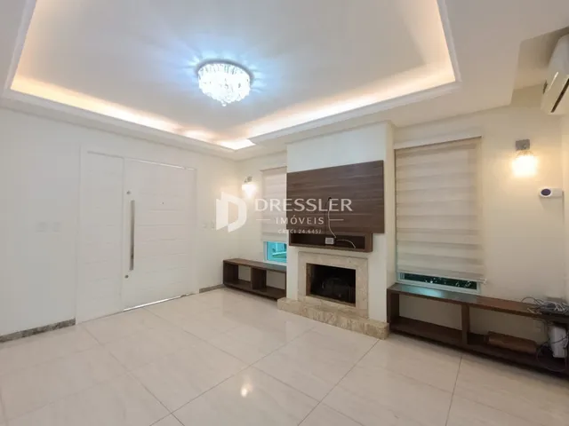 Sala de estar com piso de porcelanato e lareira em ambiente claro.
