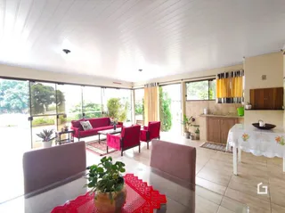 Sala de estar com piso de madeira e portas de vidro que dão para o exterior.