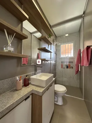 Banheiro com bancada de pedra e louças brancas em um ambiente moderno.