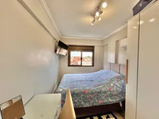 Quarto interno com cama e armários em um imóvel no Brasil.