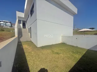 Fachada de uma casa branca com jardim gramado.