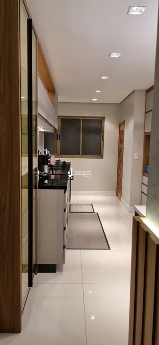 Vista da cozinha moderna com armários e piso claro.