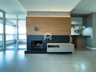Ambiente interno com lareira e grandes janelas de vidro.