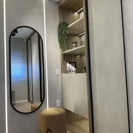 Foto de um espelho em um corredor com prateleiras de madeira.