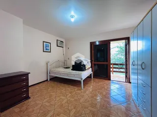Quarto com cama e armário de madeira no interior da residência.