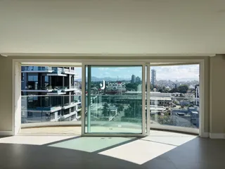 Vista da propriedade com grandes portas de vidro que dão para a paisagem urbana.