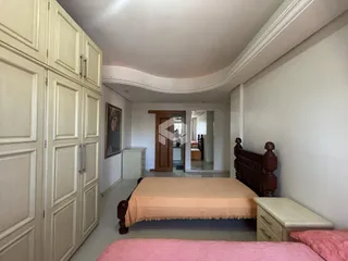 Quarto com armários embutidos e cama de madeira.