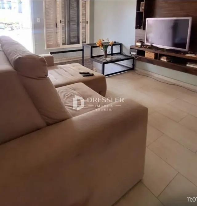 Uma sala de estar com sofá e piso de madeira.