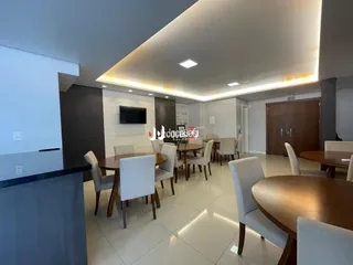 Uma sala de jantar com mesa de madeira e cadeiras em um apartamento.