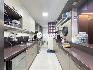 Cozinha moderna com armários e bancadas em tons de cinza e marrom.
